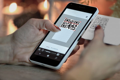 Telefono móvil escaneando un código QR de una tarjeta de visita
